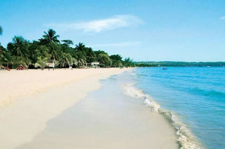 Waves washing on to the white sand of seven mile beach in Negril, Jamaica. 