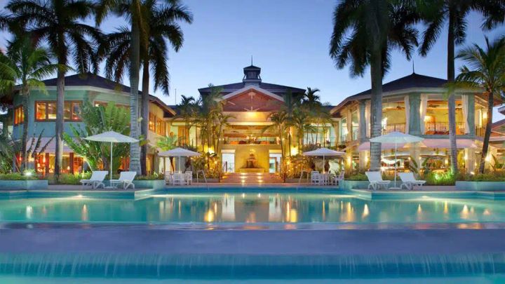 Resort with a swimming pool and white chairs in Negril, Jamaica. 