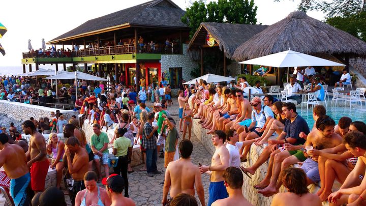 Hundreds of people hanging out and drinking at the cliff side Ricks Cafe in Negril, Jamaica.