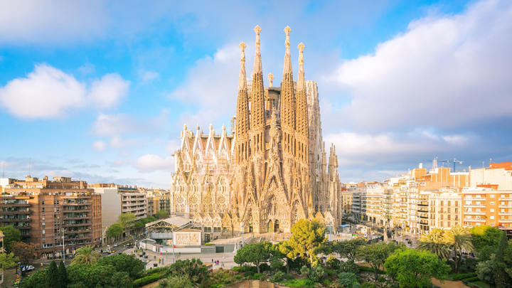 View of Sagrada Familia in Barcelona and it's surrounding buildings on a partly cloudy day.