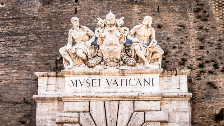 The entrance to the Vatican Museum  is a white rock door on the side of Vatican wall.