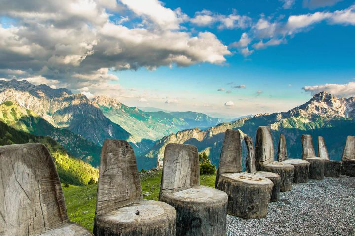 Tree stumps cut into chairs at the top of a mountain over looking the valley in Theth, Albania.
