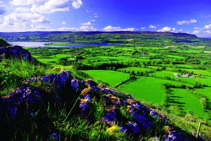 Looking down from a mountain at the lush bright green fields of Ireland.