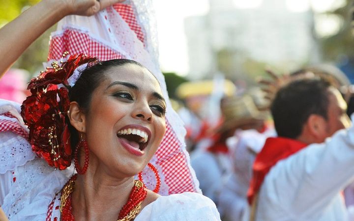A woman celebrating a festival in Bogota, Colombia dancing in the streets.