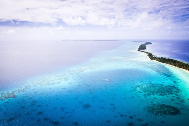 A view of a narrow island strip in crystal clear beautiful waters of Arno Atoll in the Marshall Islands.