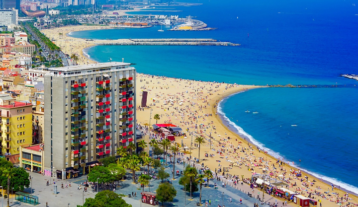 iew of the beaches in Barcelona with lots of people having fun on the beach