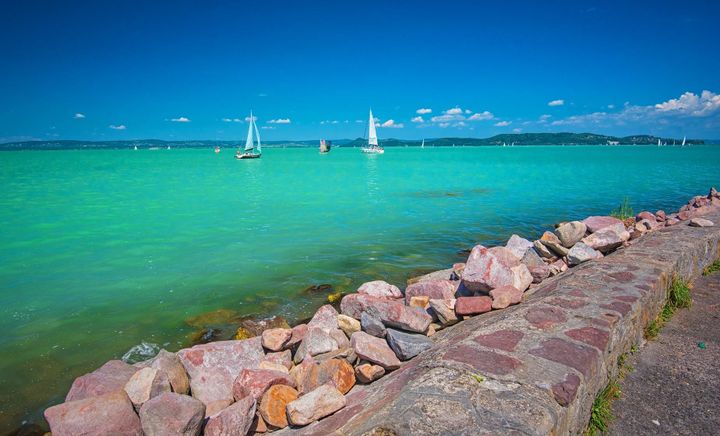 Sailboats sailing on Lake Balaton, Hungary. The lake has a beautiful milky green color to it. 
