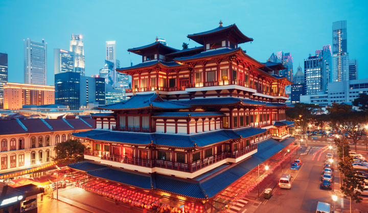Ariel view of Singapore skyline and cars driving on the street at night.