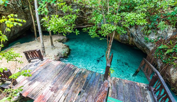 Cenote with crystal clear blue waters in Tulum, Mexico.