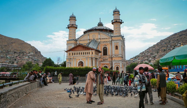 People taking photos in front of a mosque in Kabul, Afghanistan. 