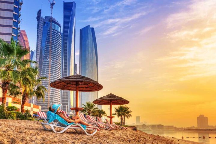 A woman laying on the beach at a beach resort in Abu Dhabi.
