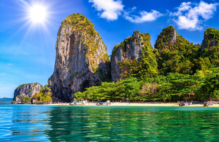A beautiful beach in Ao Nang, Thailand with large mountains behind it.