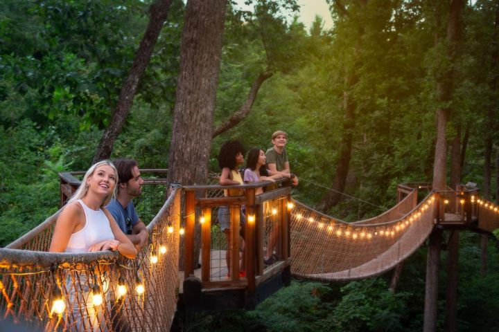 People walking on a wooden bridge in the forrest in Gatlinburg, TN.