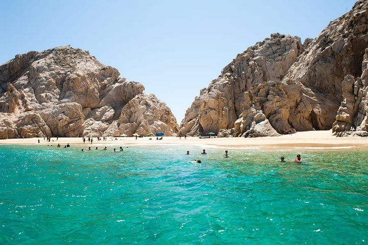 People swimming at a beautiful beach in Cabo San Lucas, Mexico.