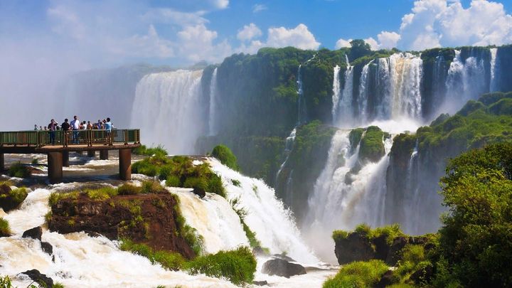 People standing on the viewing platform at Iguazú Falls, which is a giant set of waterfalls in Brazil