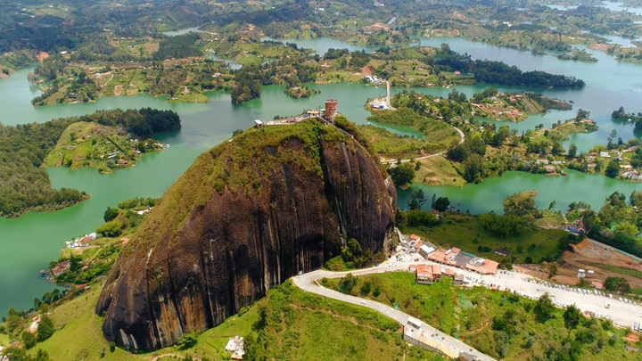 Ariel view of the famous Piedra Del Peñol in Colombia, surrounded by the lake and lush greenery. 