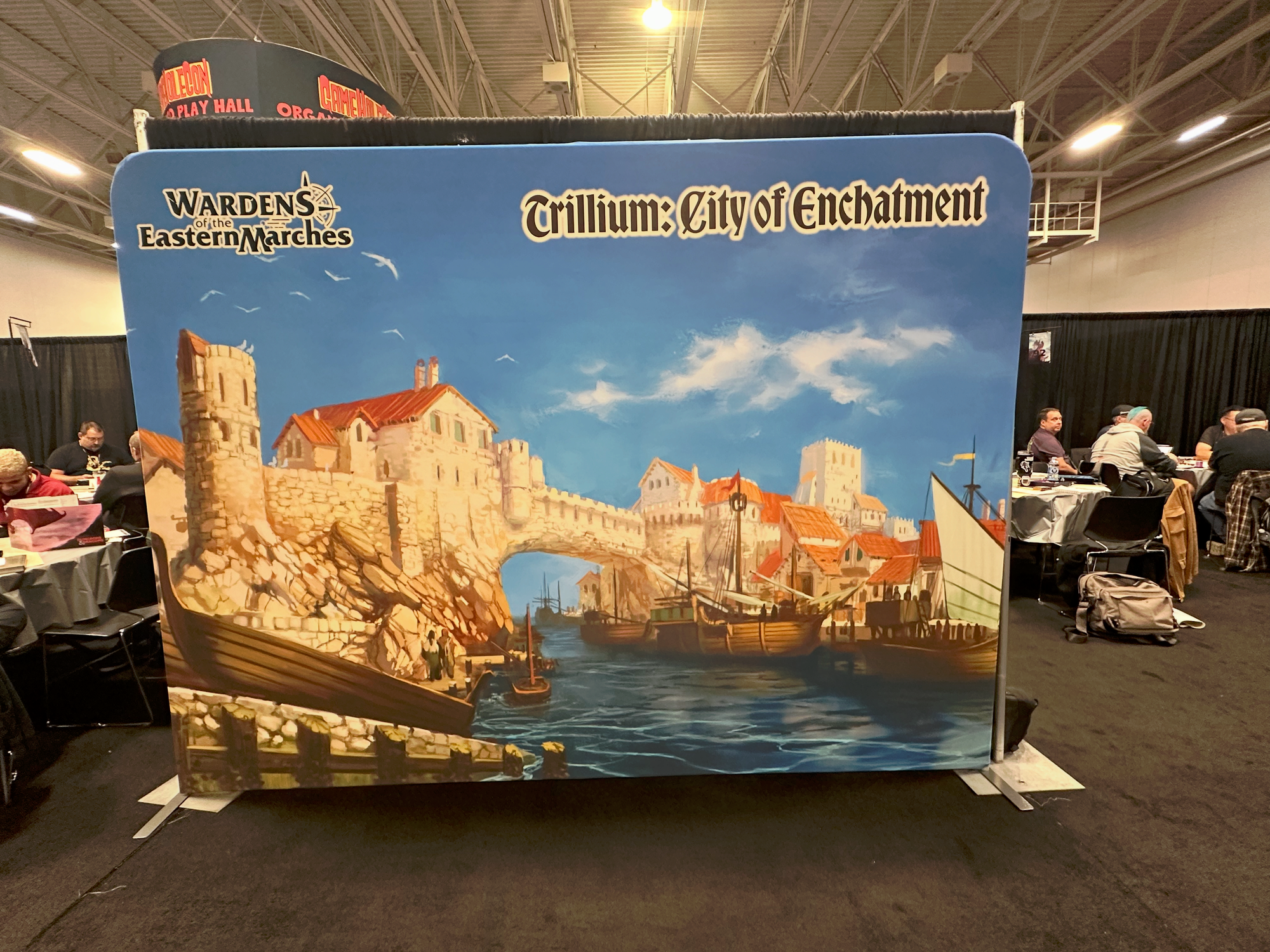 A large banner saying "Trillim: City of Enchatment" (mispelled) and depicting a city with a bridge over a harbor.