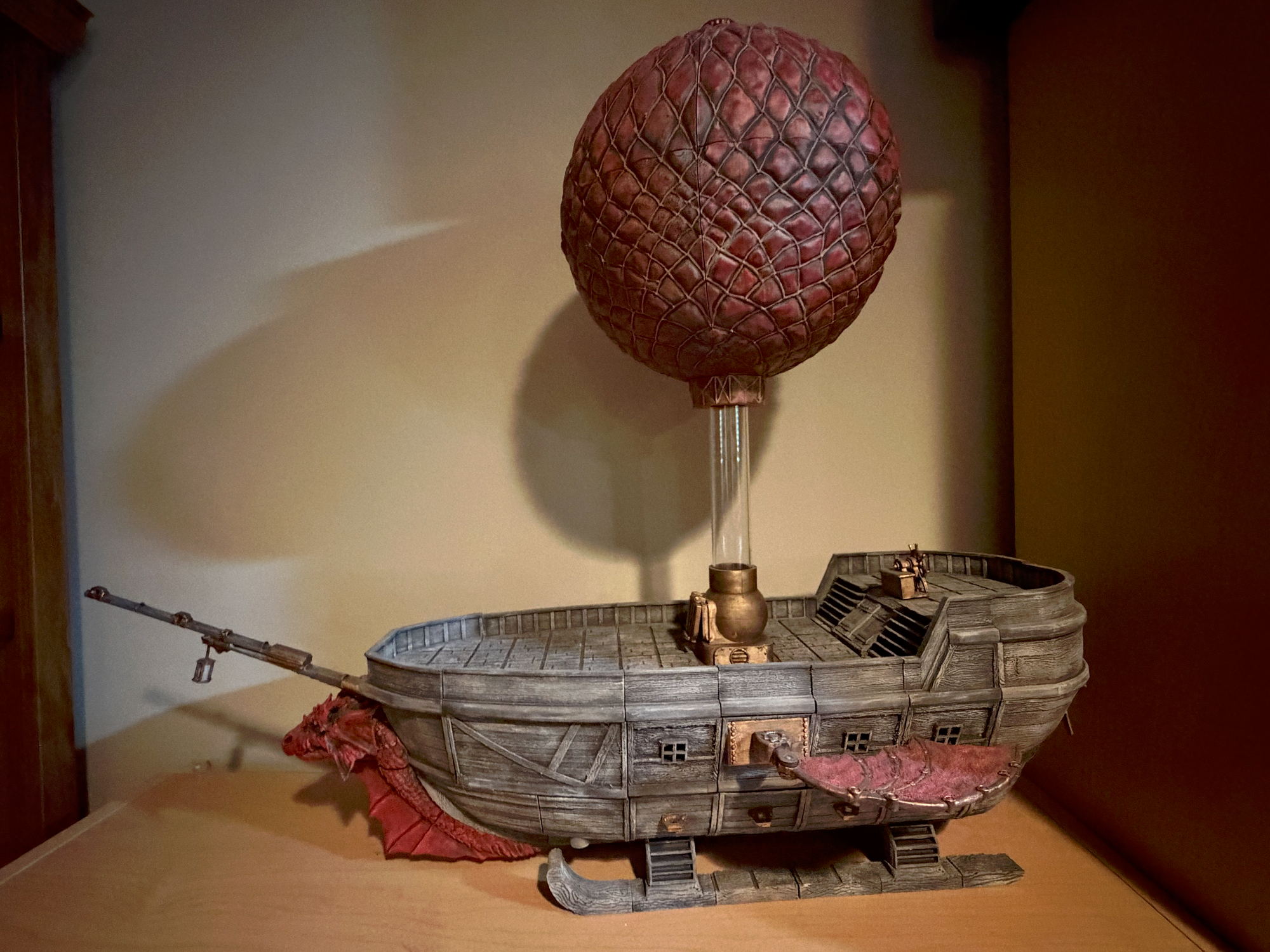 3D printed airship on skies with a dragon figurehead, wings, and a hot air balloon overhead. 