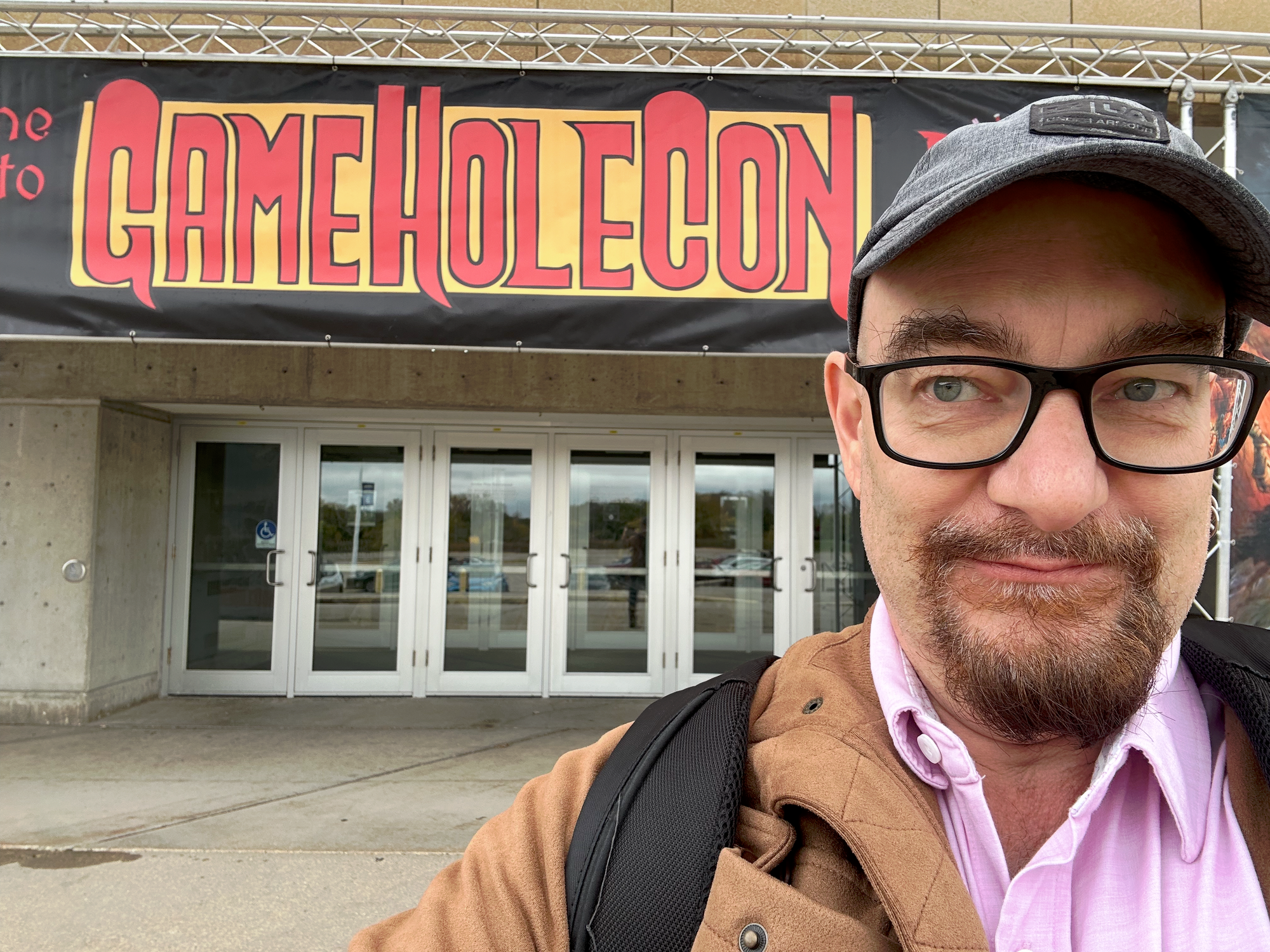 Me outside the convention center with GameHole Con sign above the doors.