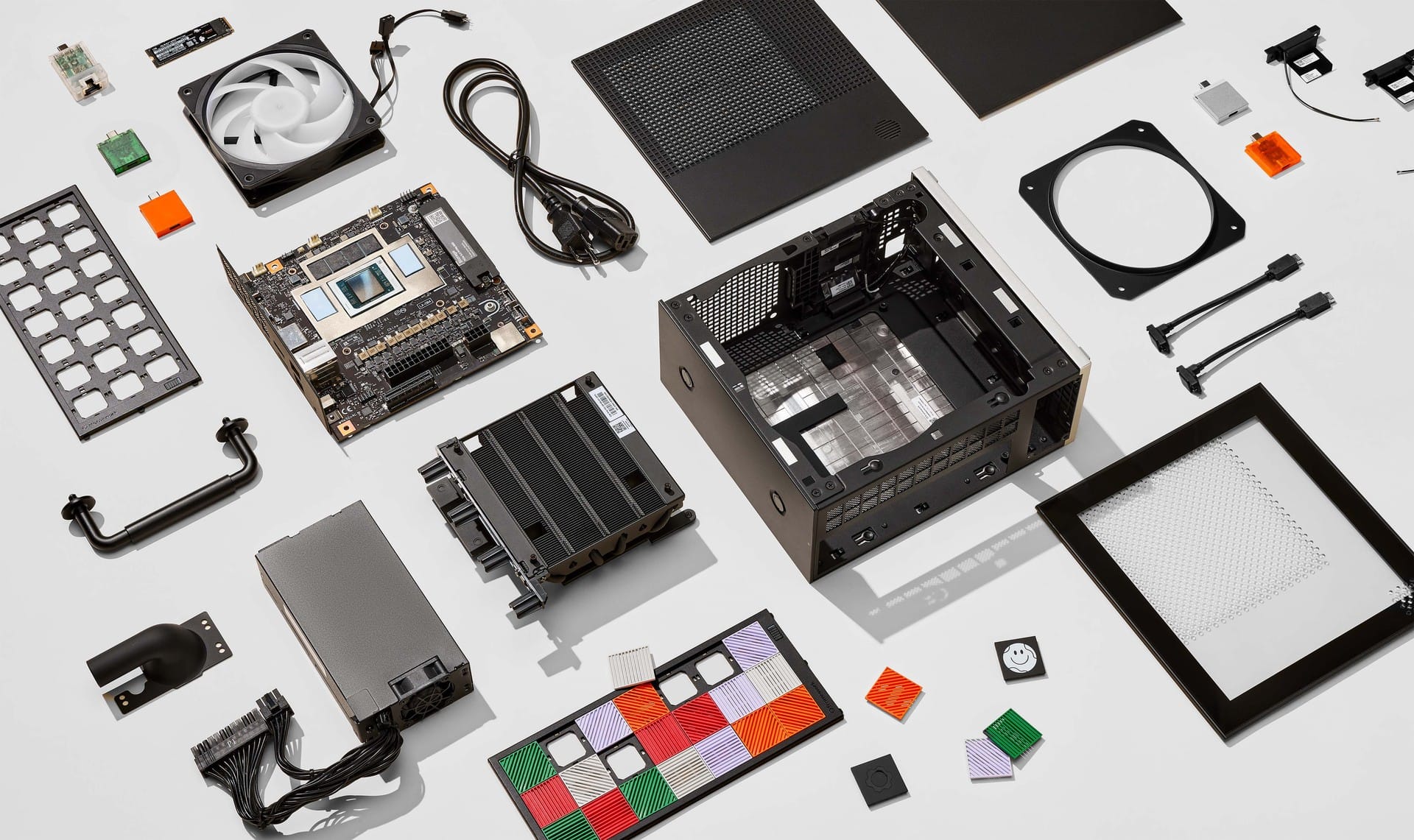 Framework Desktop parts laid out: case, mainboard, cooler, fan, power supply and front tiles
