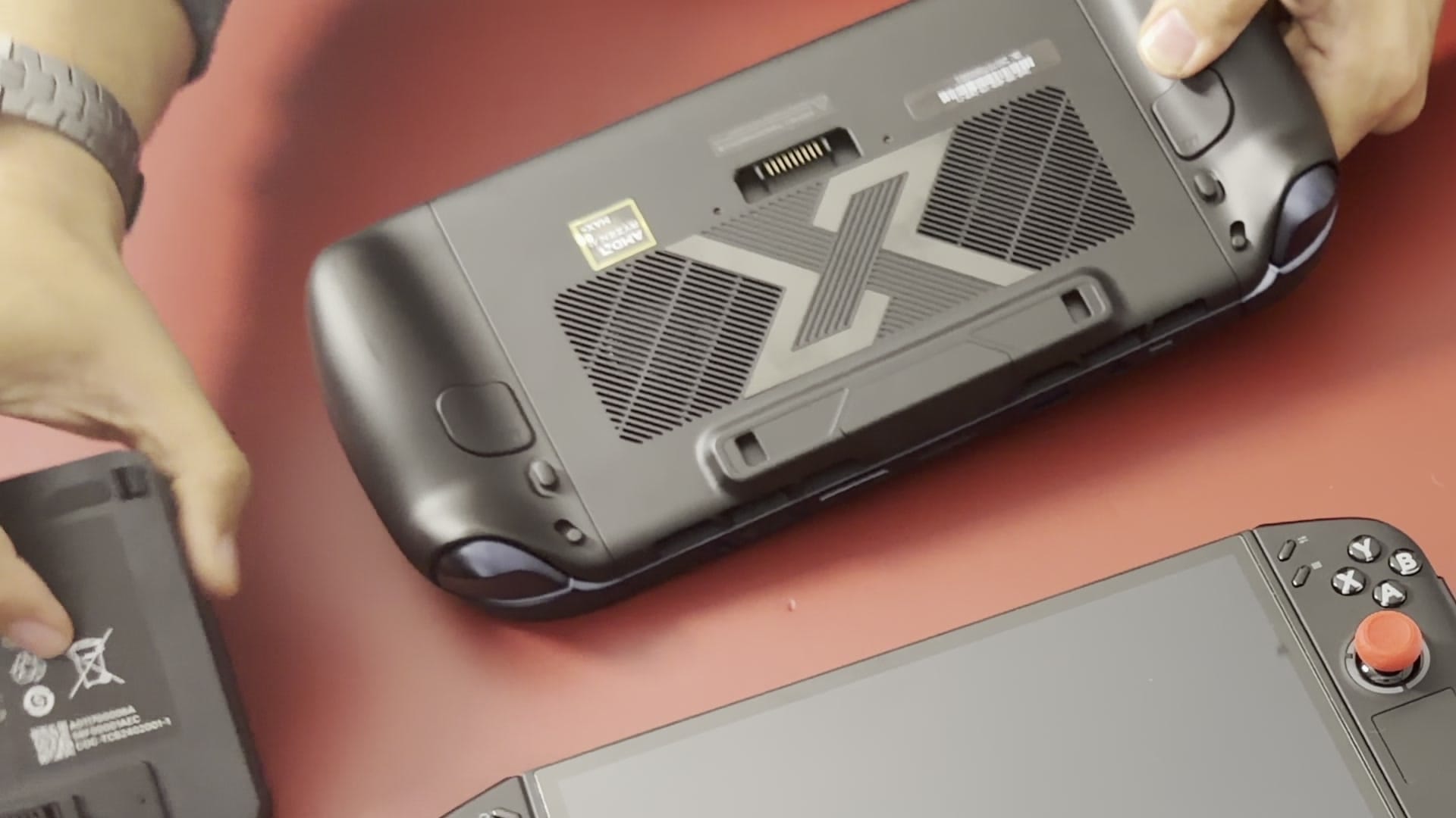 The OneXPlayer X2 Mini Pro's detached battery held beside the back of the handheld