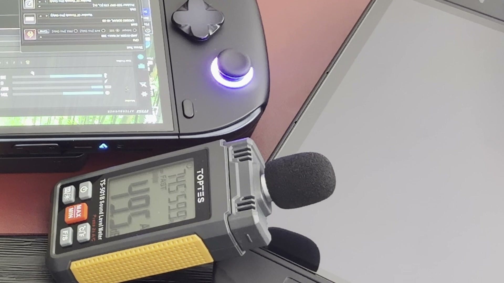 Handheld sound level meter next to the X2 Mini Pro during the fan-noise test