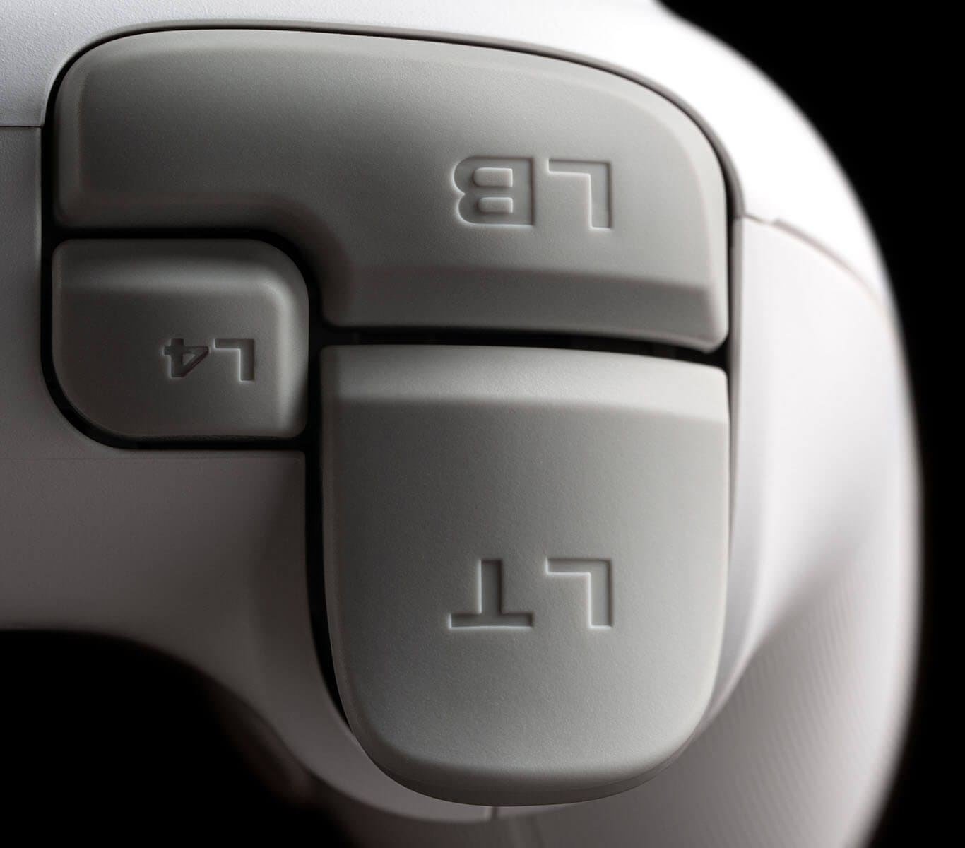 Close-up of the left shoulder of a white 8BitDo Ultimate 3C+, showing the LB bumper, the extra L4 bumper and the LT trigger