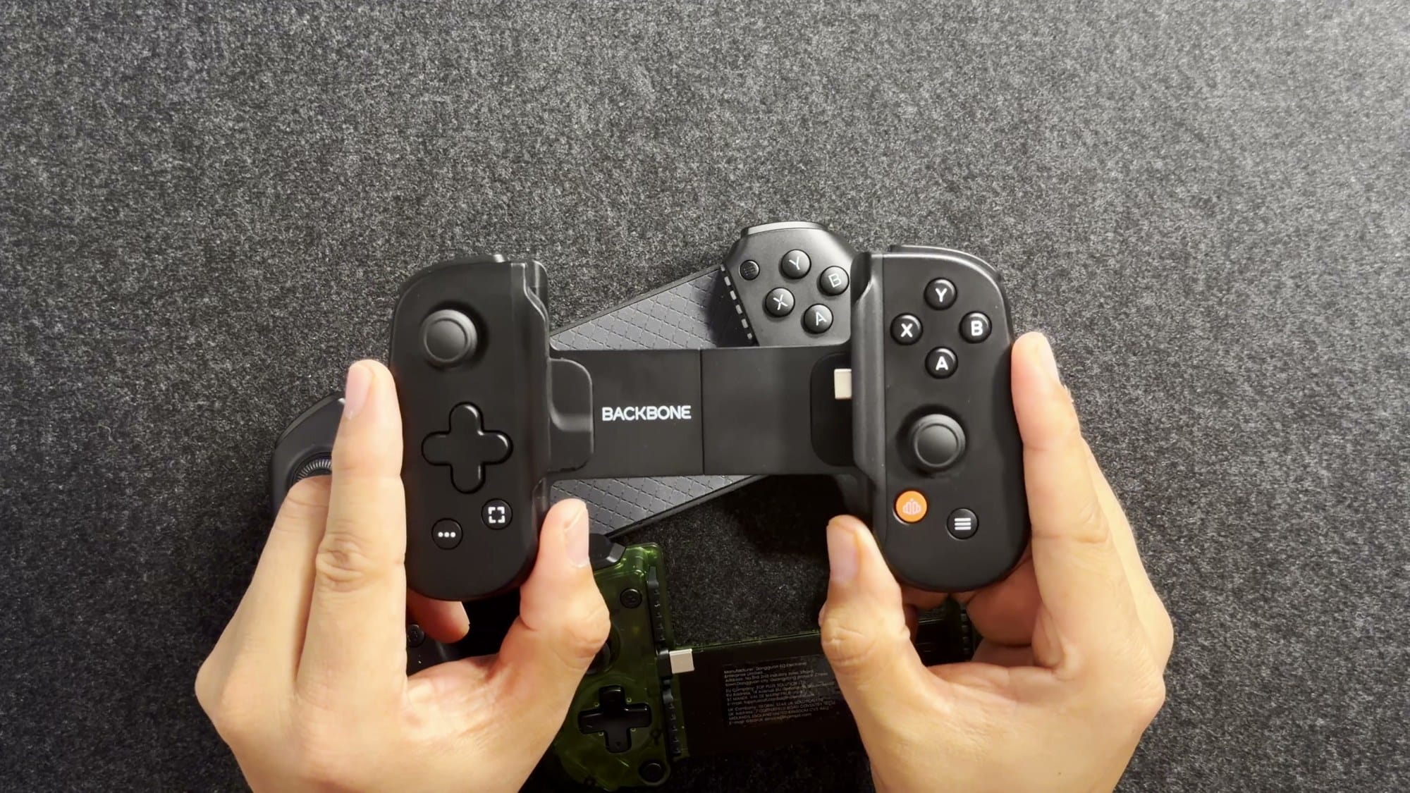 Backbone One in Victor's hands showing the face buttons and compact sticks