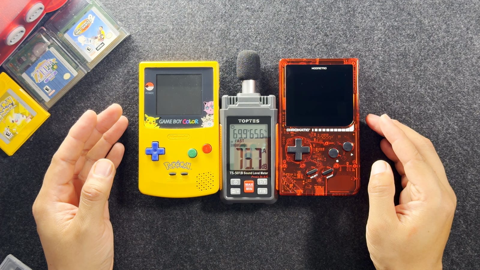 A Game Boy Color and the transparent red Chromatic lying either side of a sound level meter
