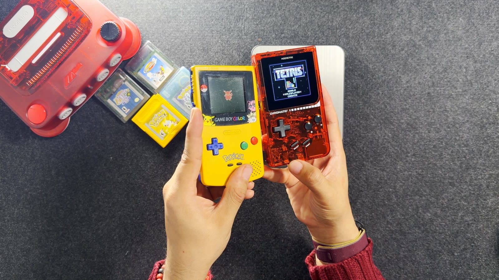 My yellow Pikachu edition Game Boy Color held next to the red Chromatic, both showing a game
