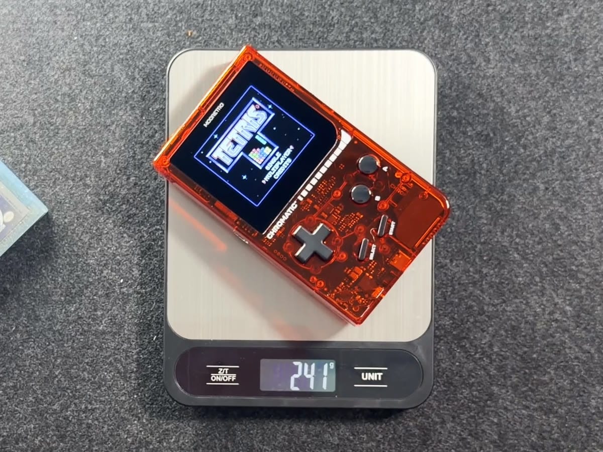 The transparent red Chromatic on a kitchen scale reading 241 grams, with Tetris on screen