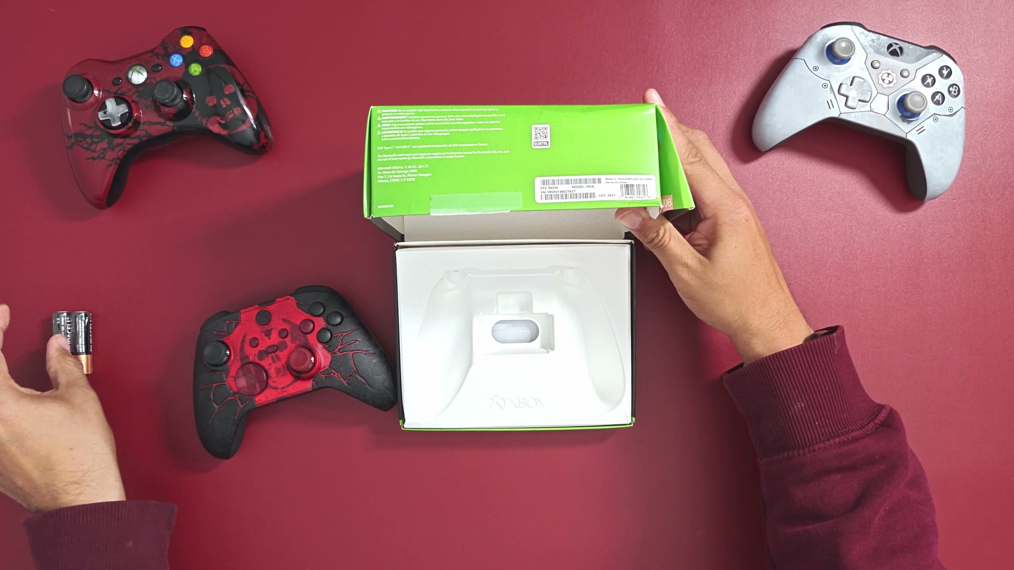 The opened controller box beside the E-Day controller and two AA batteries