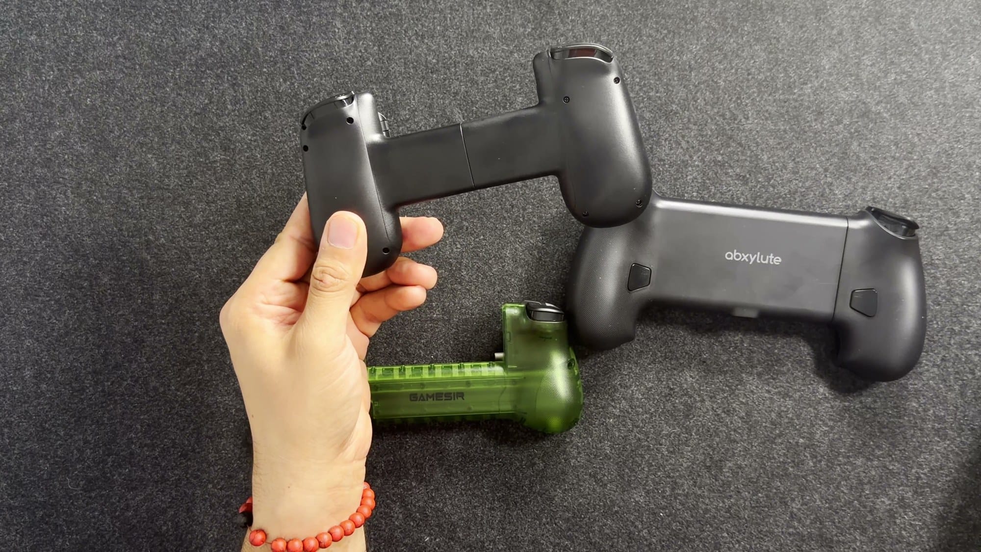 The backs of the Backbone One, abxylute S9 and GameSir X5 Lite showing their grips
