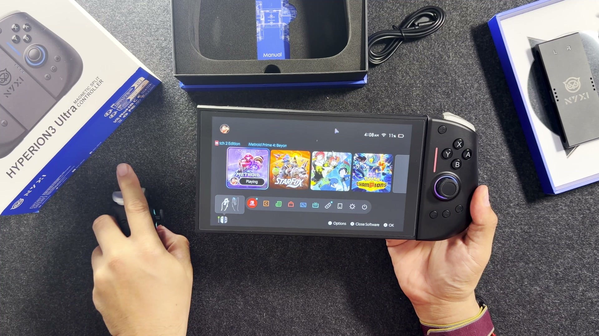 A Switch 2 with the Ultra's left half detached for mouse mode, cursor on screen