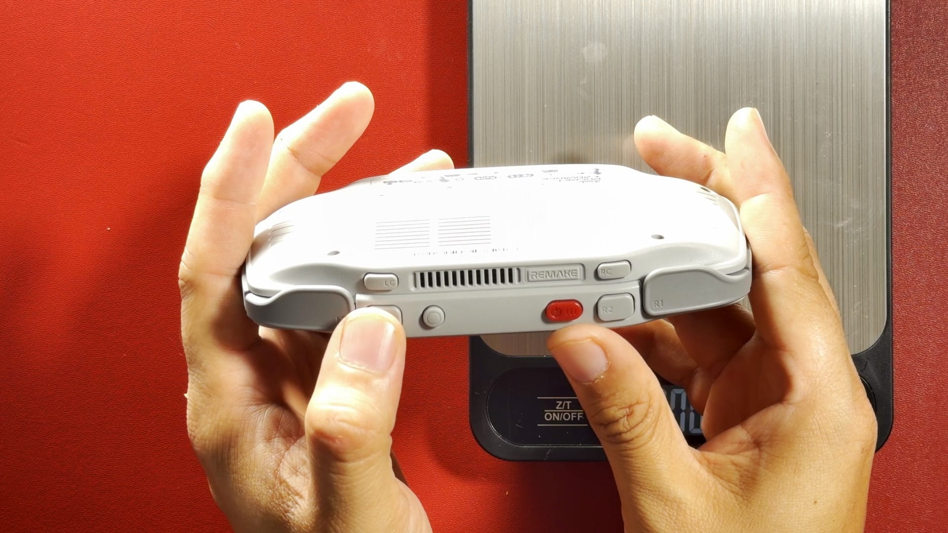 The top edge of the KONKR Pocket Advance held in two hands, showing the shoulder buttons and vents