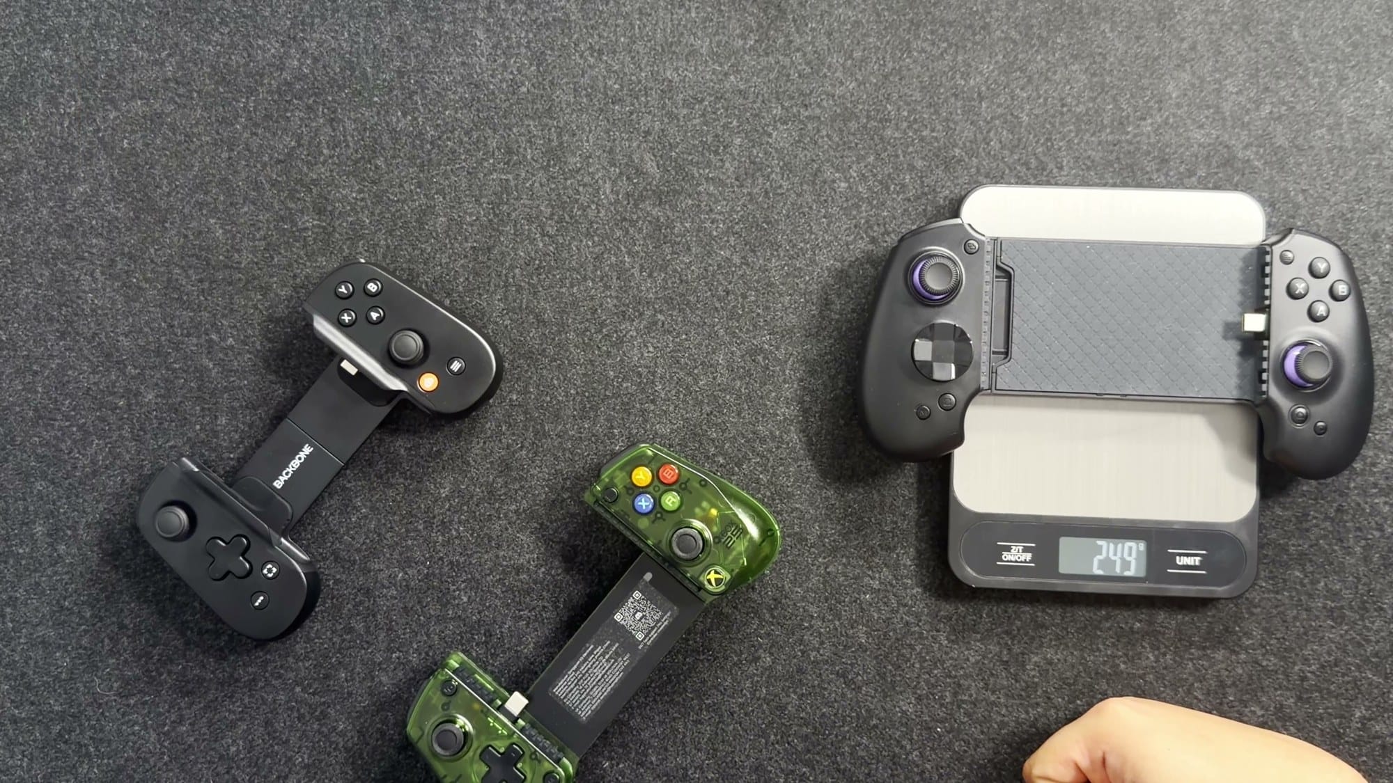 abxylute S9 on a kitchen scale reading 249 grams with the other two controllers beside it