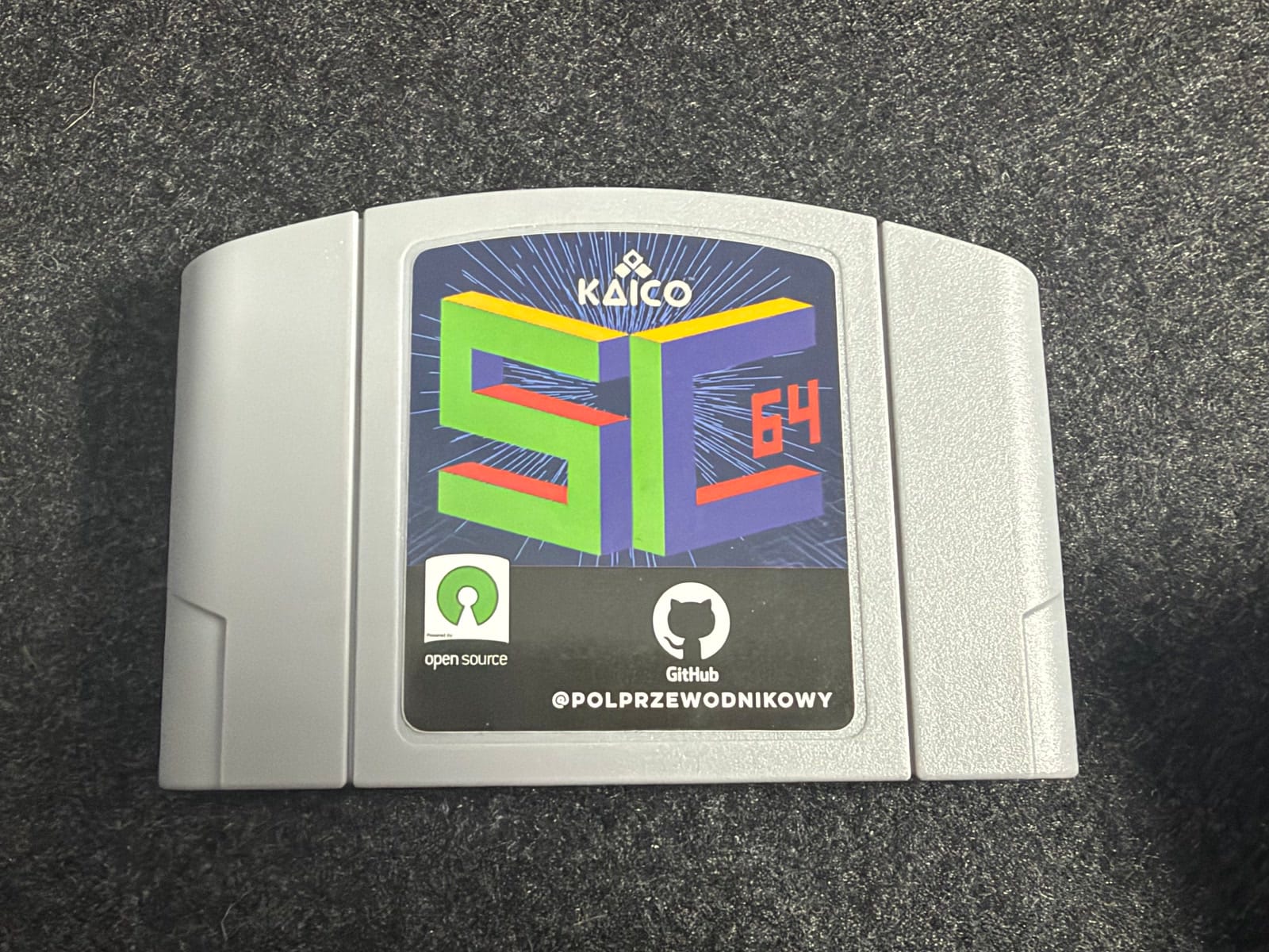 A grey SummerCart64 cartridge with a Kaico SC64 label