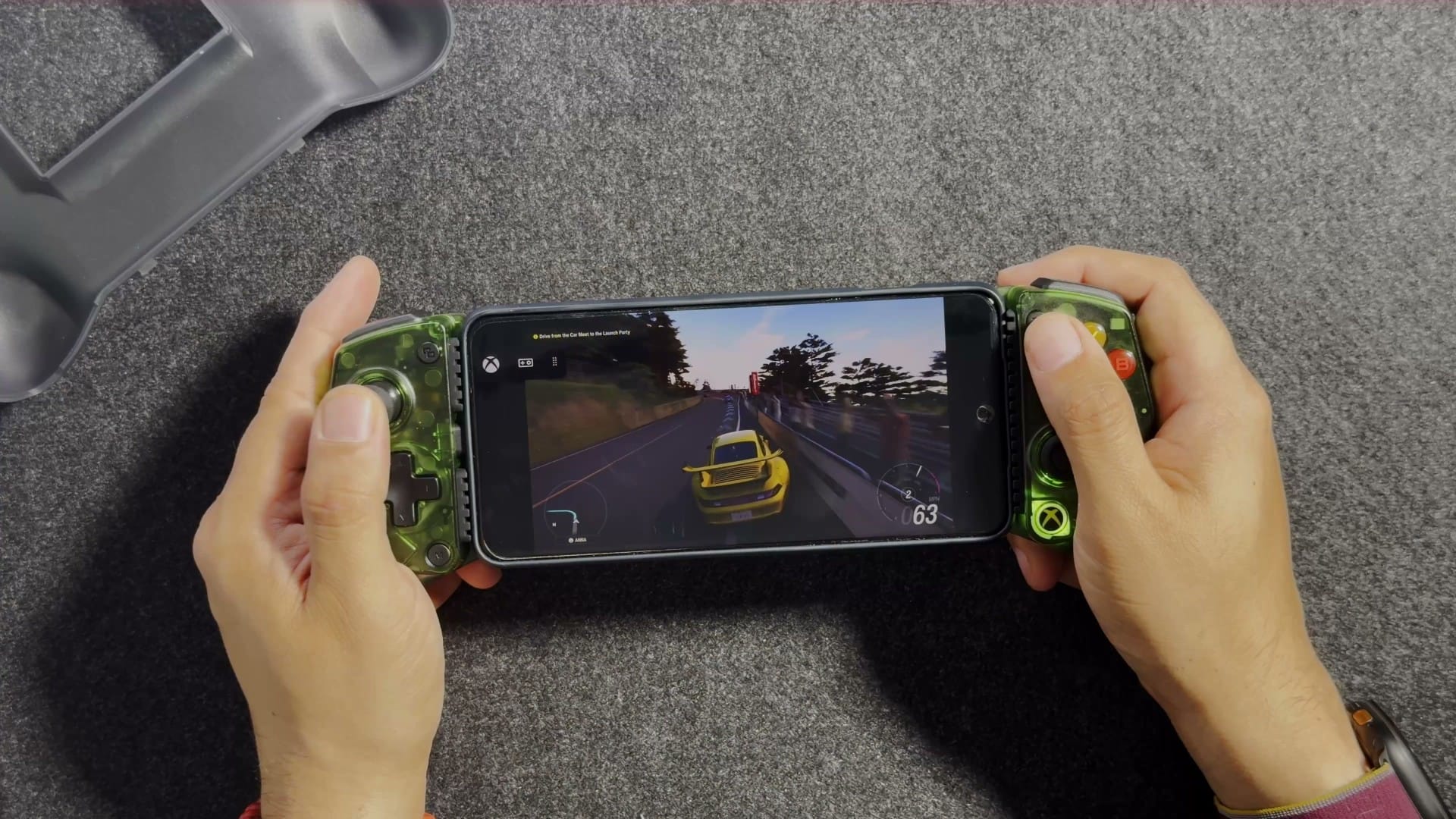 A racing game streaming on an Android phone held in the X5 Lite