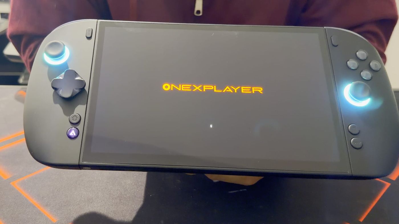 OneXPlayer X2 Mini Pro on first boot, the orange OneXPlayer logo on screen and both stick lights glowing