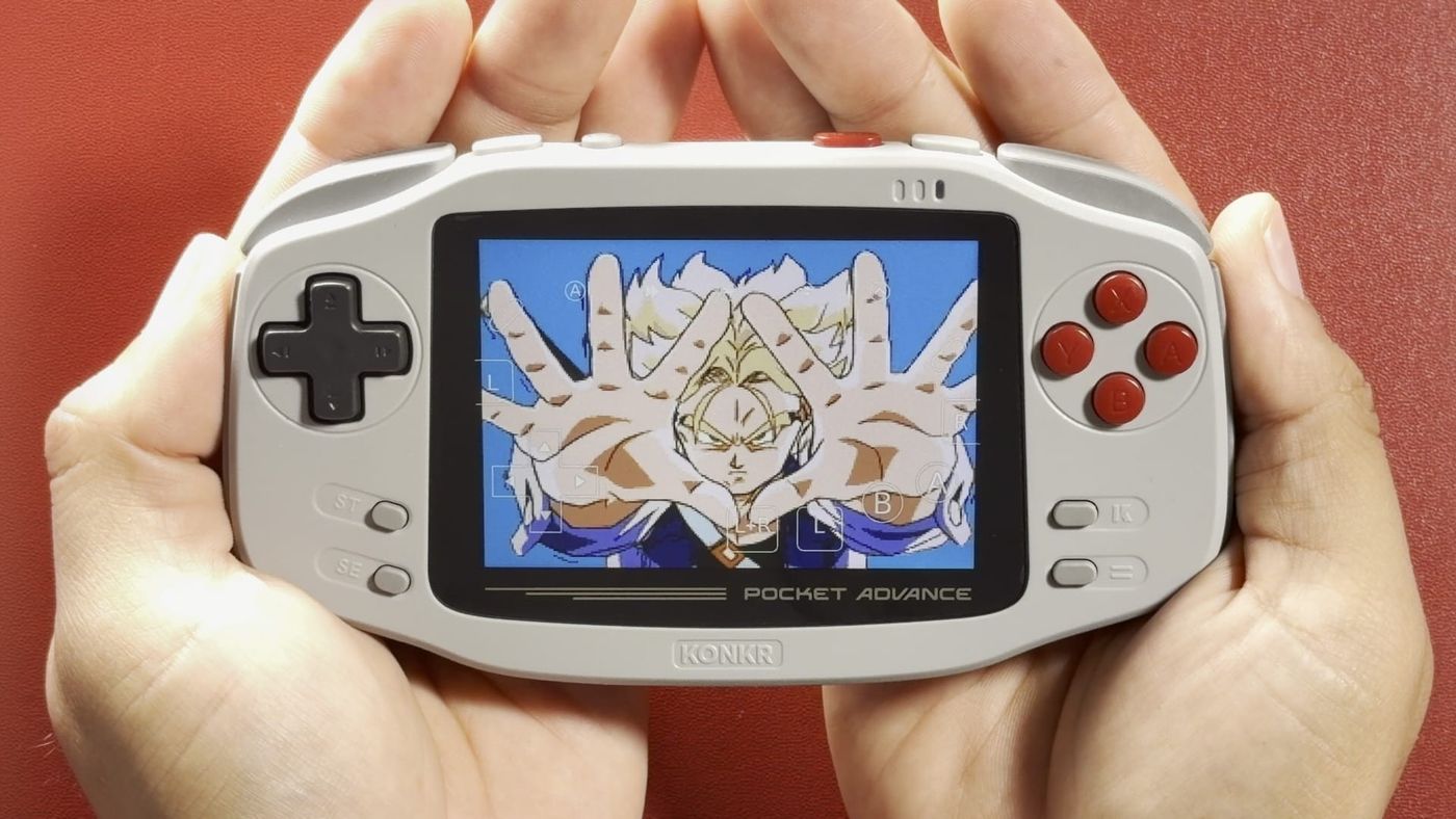 Two cupped hands holding the grey KONKR Pocket Advance, with a Dragon Ball game on screen