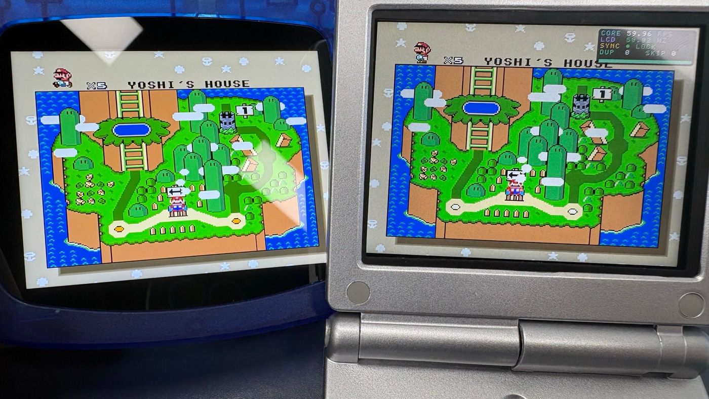 A dark blue transparent handheld prototype with a wide screen lens next to a silver clamshell FPGA handheld, both showing the same Super Mario map