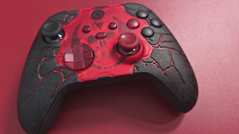 Close-up of the Gears of War E-Day Xbox controller with its translucent red front and cracked black shell