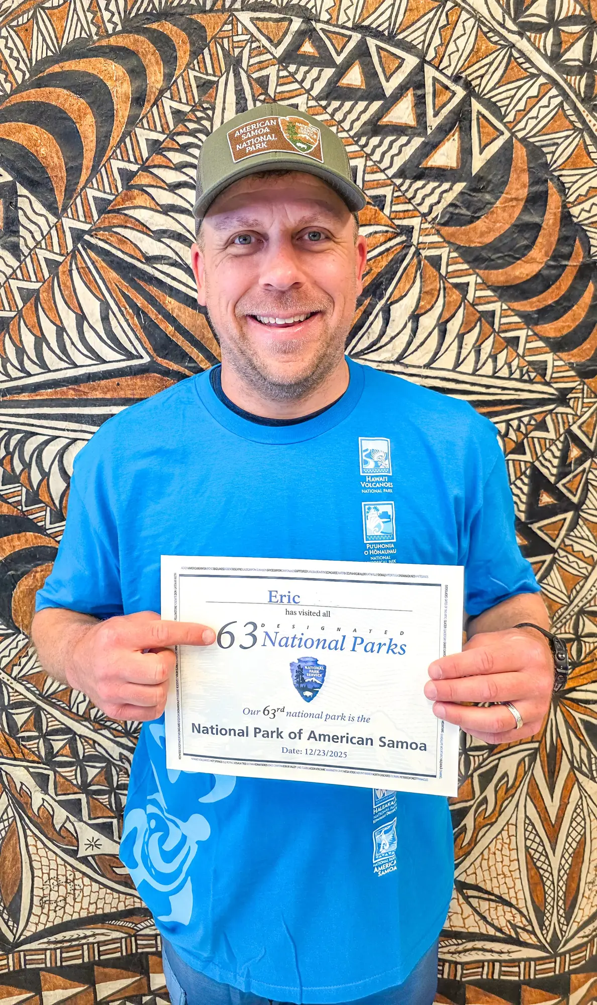 Eric Kufrin holding certificate for visiting all 63 National Parks at National Park of American Samoa visitor center