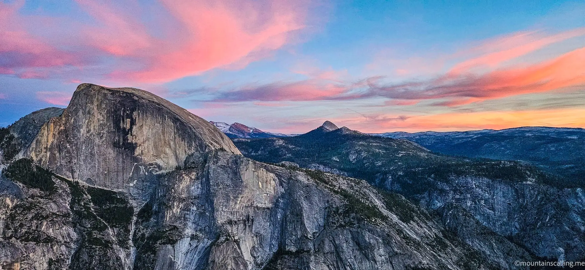 Half Dome and Yosemite high country mountains at sunset with pink and blue clouds over granite peaks