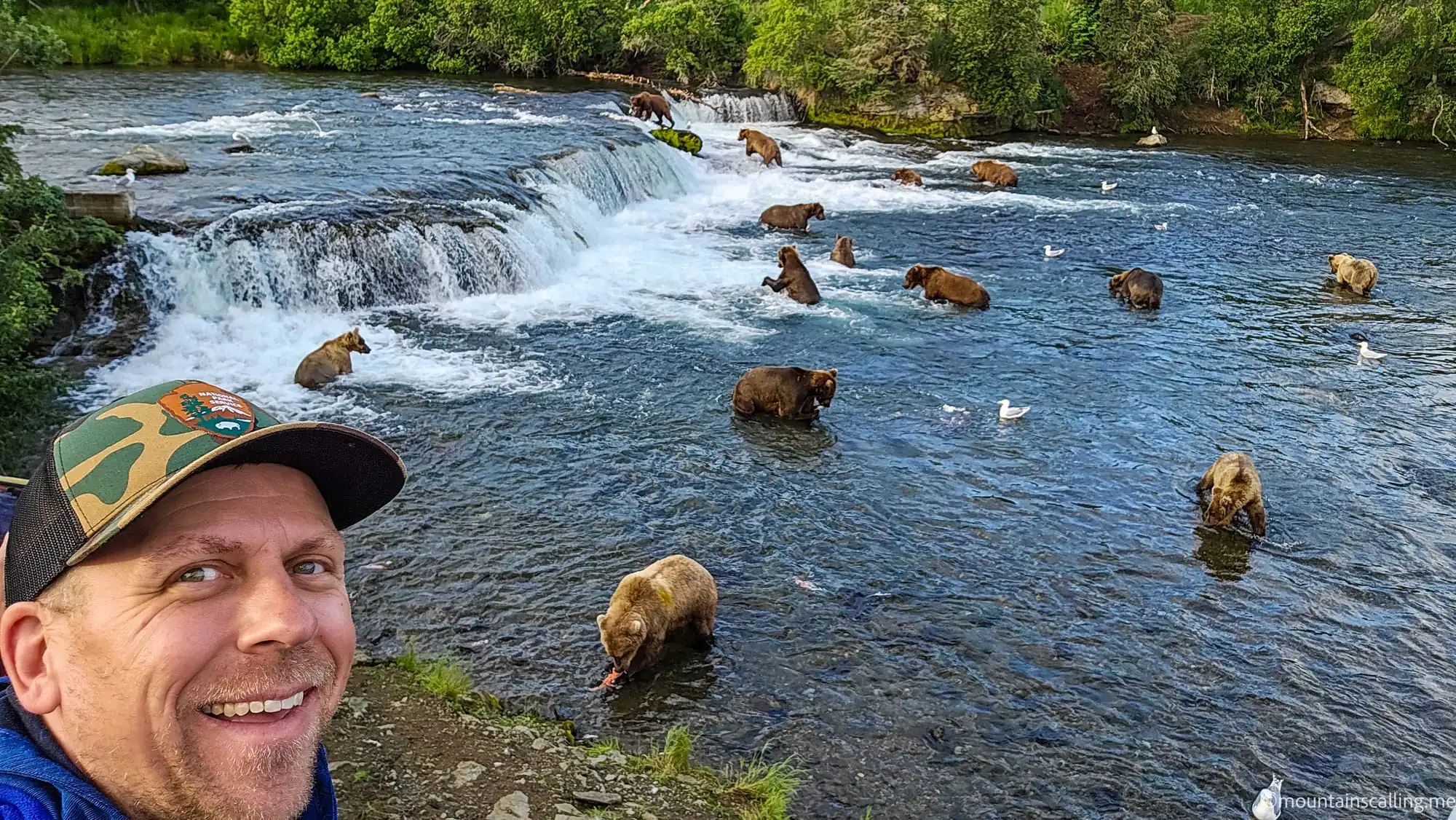 Eric Kufrin takes a selfie with dozens of brown bears fishing for salmon at Brooks Falls in Katmai National Park