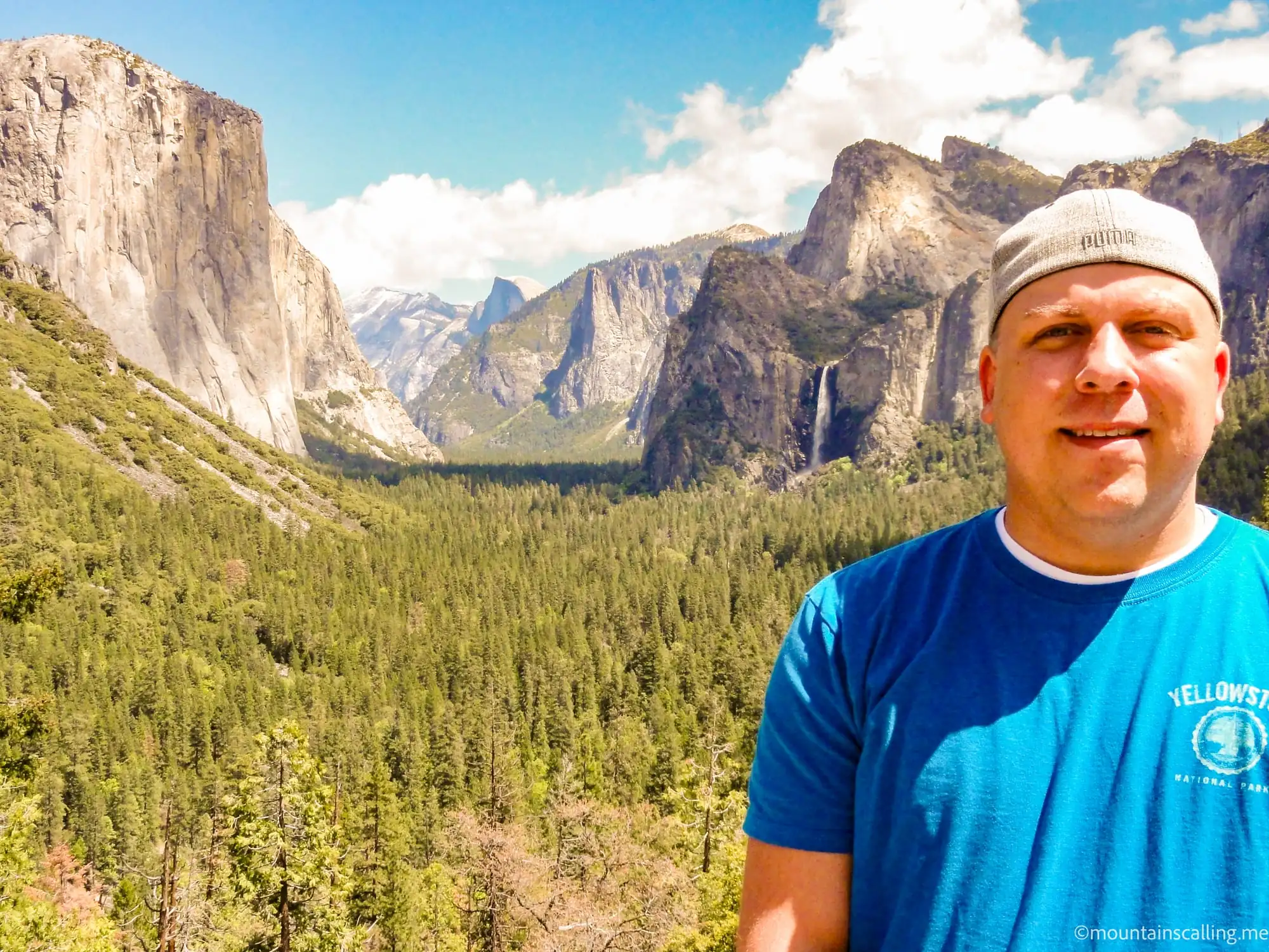 Eric Kufrin wearing a backwards hat and Yellowstone shirt standing in Yosemite Valley with El Capitan and Bridalveil Fall