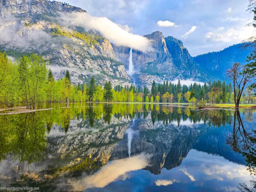 Yosemite Falls and granite cliffs perfectly reflected in calm floodwaters of the Merced River in Yosemite Valley