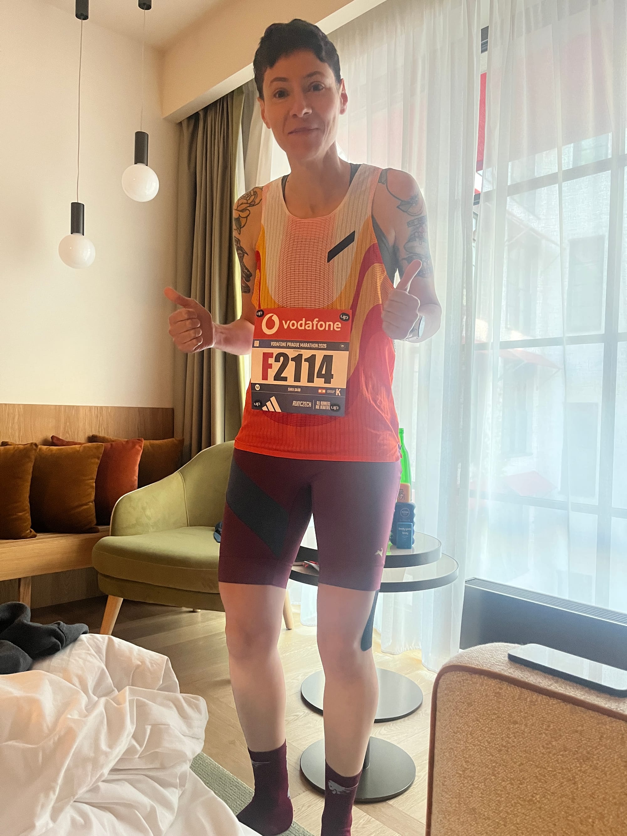 a person in a running outfit with their thumbs up because they haven’t run their marathon.