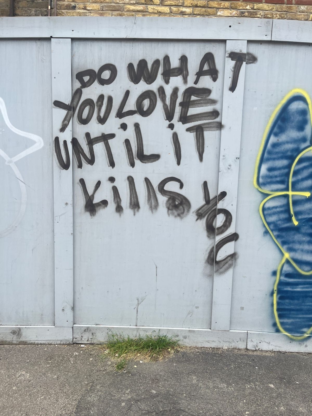 Graffiti that says “Do what you love until it kills you” with the final word tilting down vertically.
