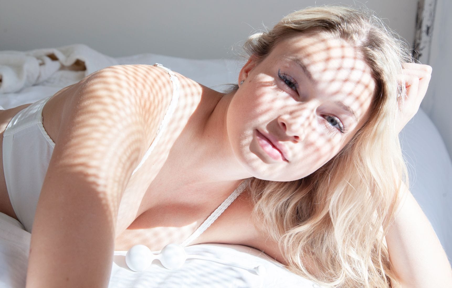 Hra světla a stínu na ženském těle jako vyjádření jemnosti, vnitřního klidu a intimního wellbeingu.